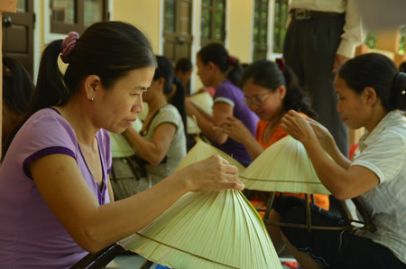 Phụ nữ thôn Trà Lộc tập trung chằm nón.    N.X