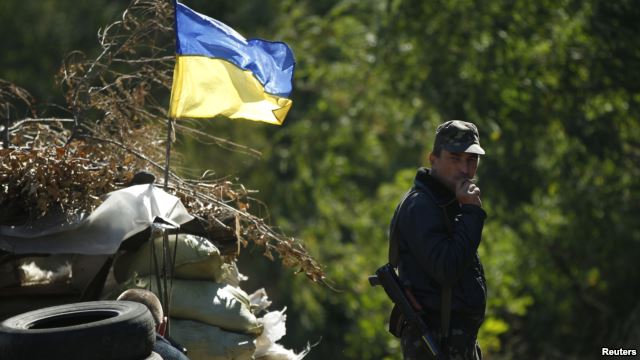 Một binh sỹ Ukraine đứng hút thuốc gần một chốt kiểm soát ở vùng Donetsk.