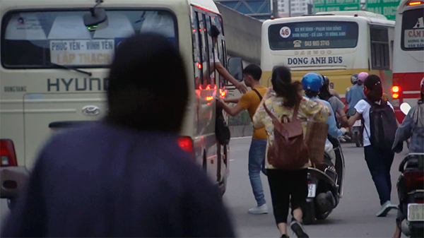 Xe dù dừng bắt khách gây nguy hiểm cho người đi đường, khiến giao thông trở nên hỗn loạn.