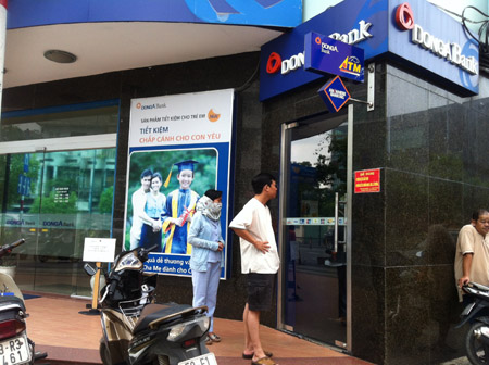 Khách hàng chờ đợi trước ATM của Ngân hàng Đông Á. 
