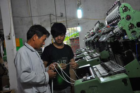 Ông Chung (trái) hướng dẫn công nhân dệt vải.