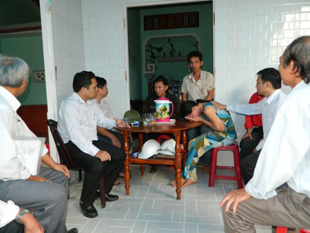 Chị Hồng vợ nạn nhân Xuân (cúi mặt) khóc nghẹn khi đoàn của huyện Tiên Phước đến thăm gia đình nạn nhân - ảnh Minh An.