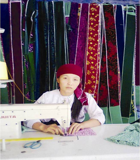 Chị Vừ Thị Mỷ miệt mài bên chiếc máy khâu may trang phục người Mông.