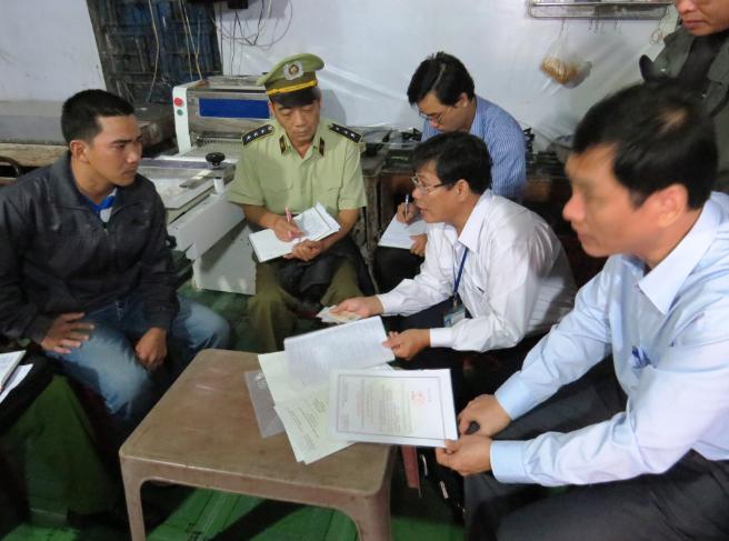 Đoàn công tác làm việc với chủ tiệm bánh Quang Trung, chi nhánh thị trấn Khe Sanh, huyện Hướng Hóa (người mặc áo đen).