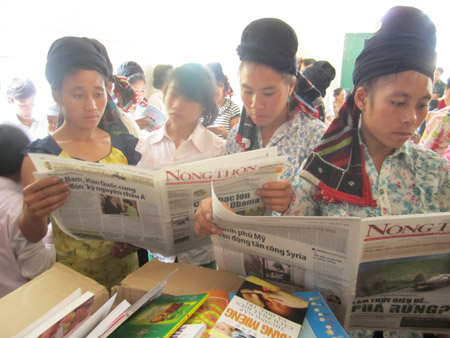 Bà con dân tộc Sinh Mun bản Tà Ẻn, xã Phiêng Khoài, huyện Yên Châu, Sơn La, thích thú đọc báo NTNN.