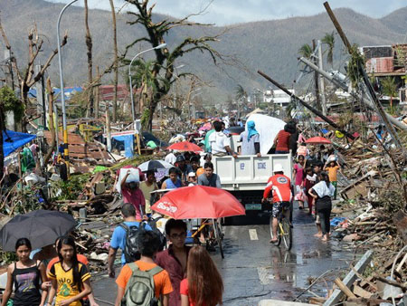 Người dân Philippines bên đống đổ nát, ngày 10/11. (Ảnh: AFP/TTXVN)