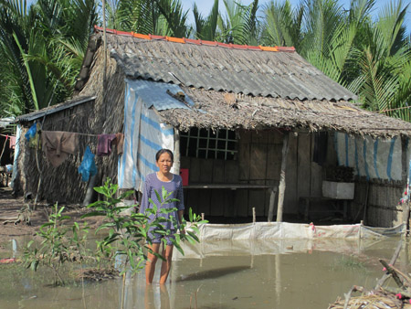 Chị Lê Kim Duyên ở ấp Mương Điều B bên căn nhà ngập nước.