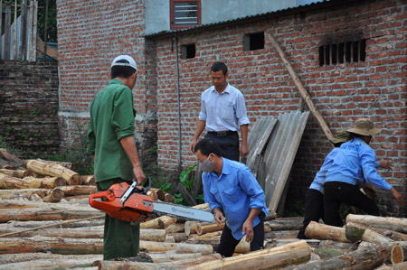 Ông Hồng (áo trắng) giám sát công nhân xẻ gỗ.