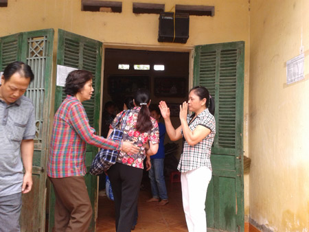 Bà Phan Thị Chanh (phải) vừa hát, vừa bắt tay để chữa bệnh.