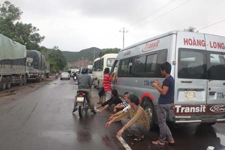 Ô tô và hành khách đang vật vạ “đứng bánh” trên QL1A tại huyện Tuy Phước (Bình Định)