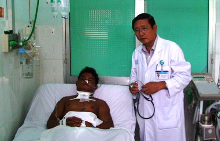 Bác sĩ Trần Quang Bính khám bệnh cho anh Điểu Rê bị rắn hổ cắn.