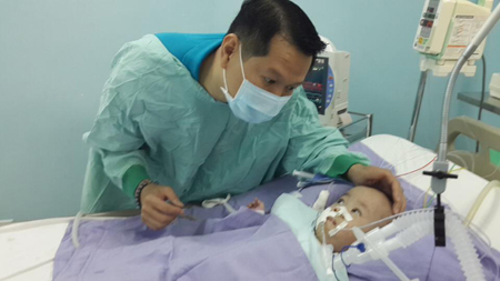Bác sĩ Trương Quang Định và bé Phi Long tại phòng hồi sức Bệnh viện Nhi Đồng 2 sáng 30.11.