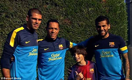 Cậu bé Gabriel chụp ảnh cùng các cầu thủ đội tuyển Barcelona Víctor Valdés (trái), Adriano (giữa) và Daniel Alves (phải).