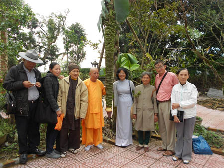 Hòa thượng Thích Lương Phương (áo vàng) và nhiều du khách thích thú chụp ảnh với buồng chuối khủng