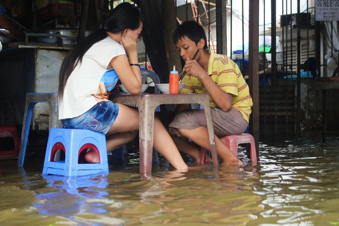 Hai chị em ngâm chân trong nước ăn sáng.