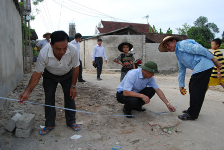 Cán bộ Huyện ủy Đức Thọ kiểm tra diện tích đất bà con thôn Tân Định hiến đất làm giao thông nông thôn.