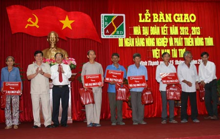 Ông Nguyễn Phong Quang - Phó ban Thường trực Ban chỉ đạo Tây Nam bộ và ông Võ Hồng - Thành viên Hội đồng Thành viên Agribank trao bảng tượng trưng tặng nhà Đại đoàn kết cho các hộ nghèo