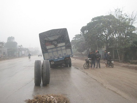 Chiếc xe tải và hai bánh bị rớt, lăn trên đường.