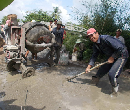 Nông dân xã Vĩnh Thanh tham gia làm đường bê tông.