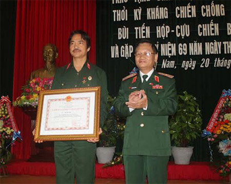 Cựu chiến binh Bùi Tiến Hợp (trái) nhận danh hiệu Anh hùng LLVTND sáng 20.12.