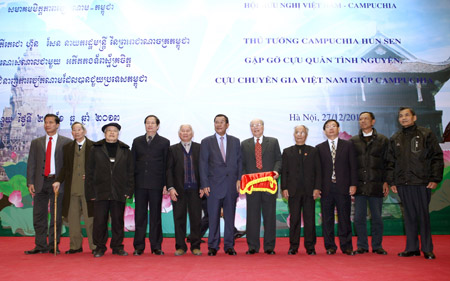 Thủ tướng Hun Sen (thứ 6 từ trái) trao quà tặng cho các cựu chuyên gia, cựu quân tình nguyện Việt Nam.  TTXVN