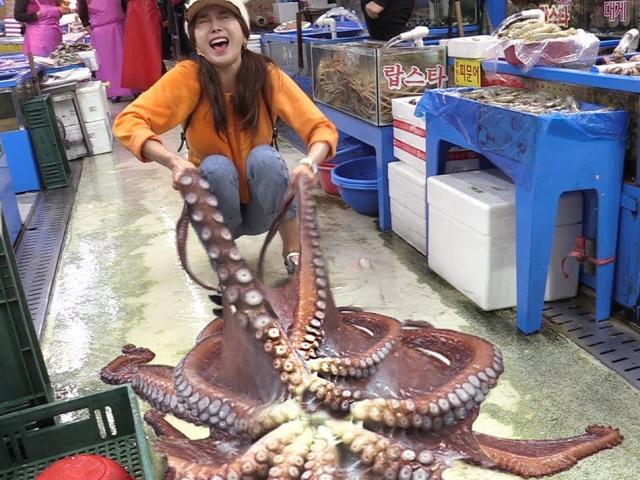Thiếu nữ xinh đẹp ”vật lộn” sơ chế bạch tuộc khổng lồ nặng 13kg