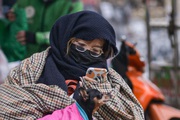 Hà Nội: Nhiệt độ xuống 12 độ C, người dân mặc áo mưa ra đường và đốt lửa sưởi ấm