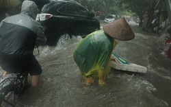 Người và xe ngã sõng soài trên đường phố Hà Nội trong cơn mưa