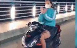 Cô gái chạy xe máy không đội mũ bảo hiểm, thả 2 tay... múa quạt 