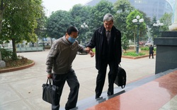 Cựu Bộ trưởng Vũ Huy Hoàng vịn cầu thang, nắm tay luật sư khi bước lên bậc thềm tòa án