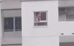 Hãi hùng cảnh bé trai vắt vẻo trên thành cửa sổ tầng cao chung cư