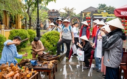 Bất chấp mưa lớn, du khách đội nón lá, thích thú tham quan phố cổ Hội An ngày Tết Dương lịch 2024