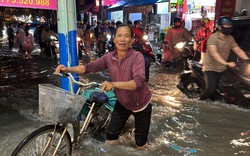 Mưa lớn kéo dài, người và xe té ngã trong nước ngập 